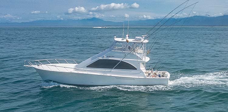 Hooked Up running offshore, a 52-foot supersport with outriggers out and mountains on the horizon.