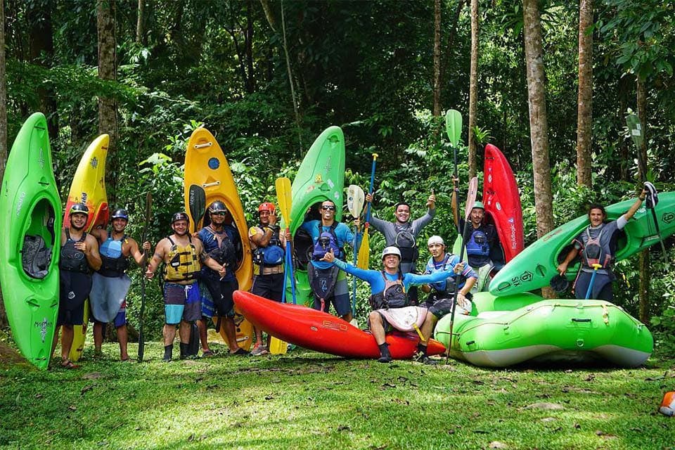The crew lined up in front of the kayaks and rafts on the grass before the put-in.